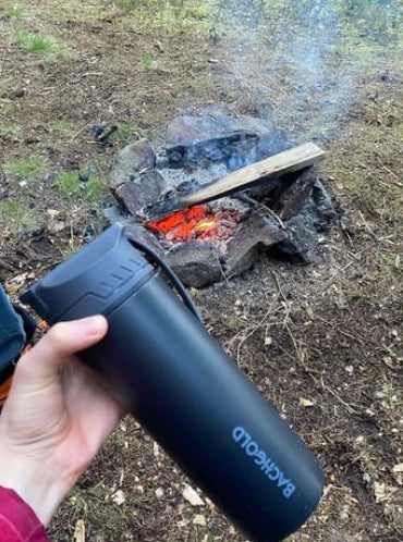 Flasche am Lagerfeuer im Wald