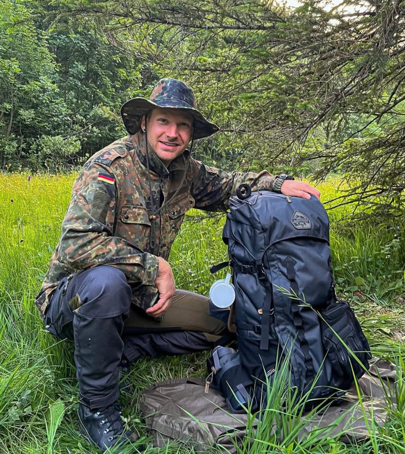 Rast auf der Wiese mit Rucksack und Trinkbecher
